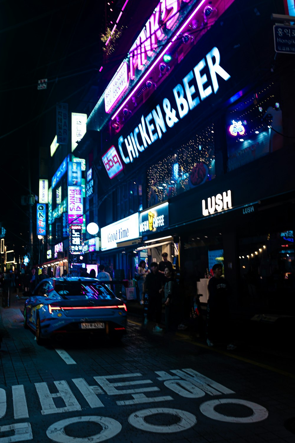 Uma rua movimentada da cidade à noite com placas de neon