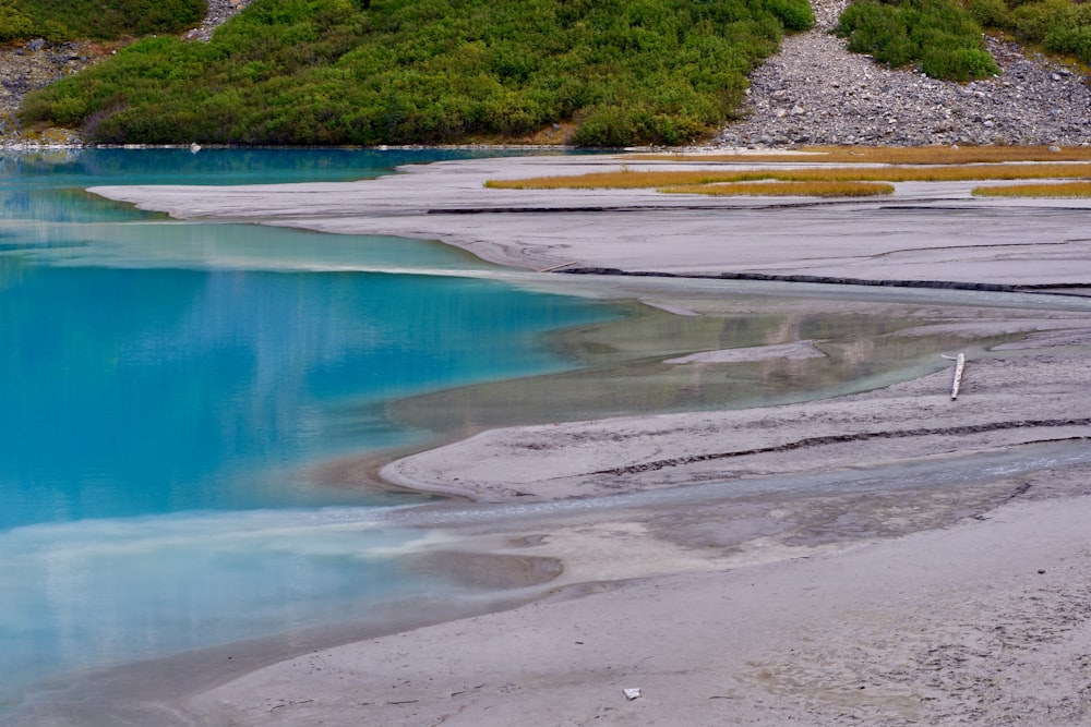 a body of water with a hill in the background