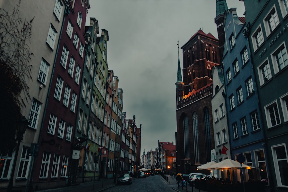 a city street lined with tall buildings under a cloudy sky