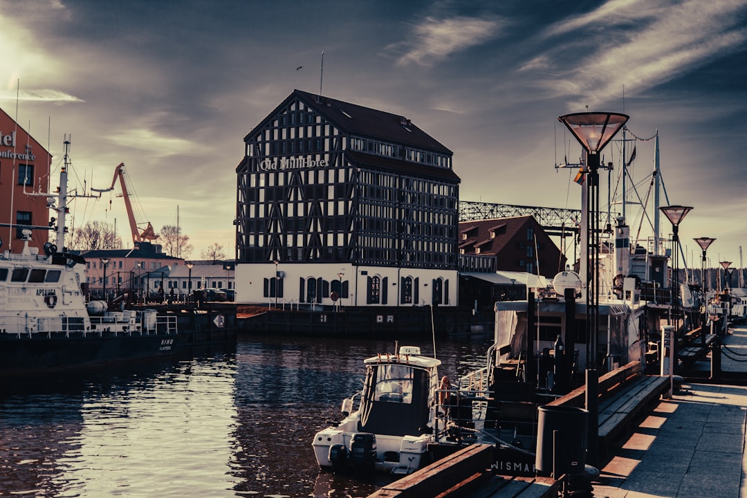 a boat docked in a harbor next to a tall building,
