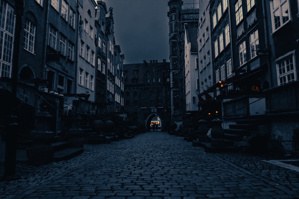 a cobblestone street with a clock tower in the background