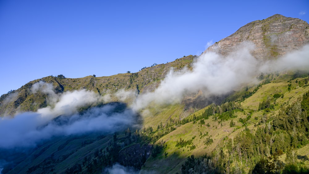 a view of a mountain with clouds coming out of it