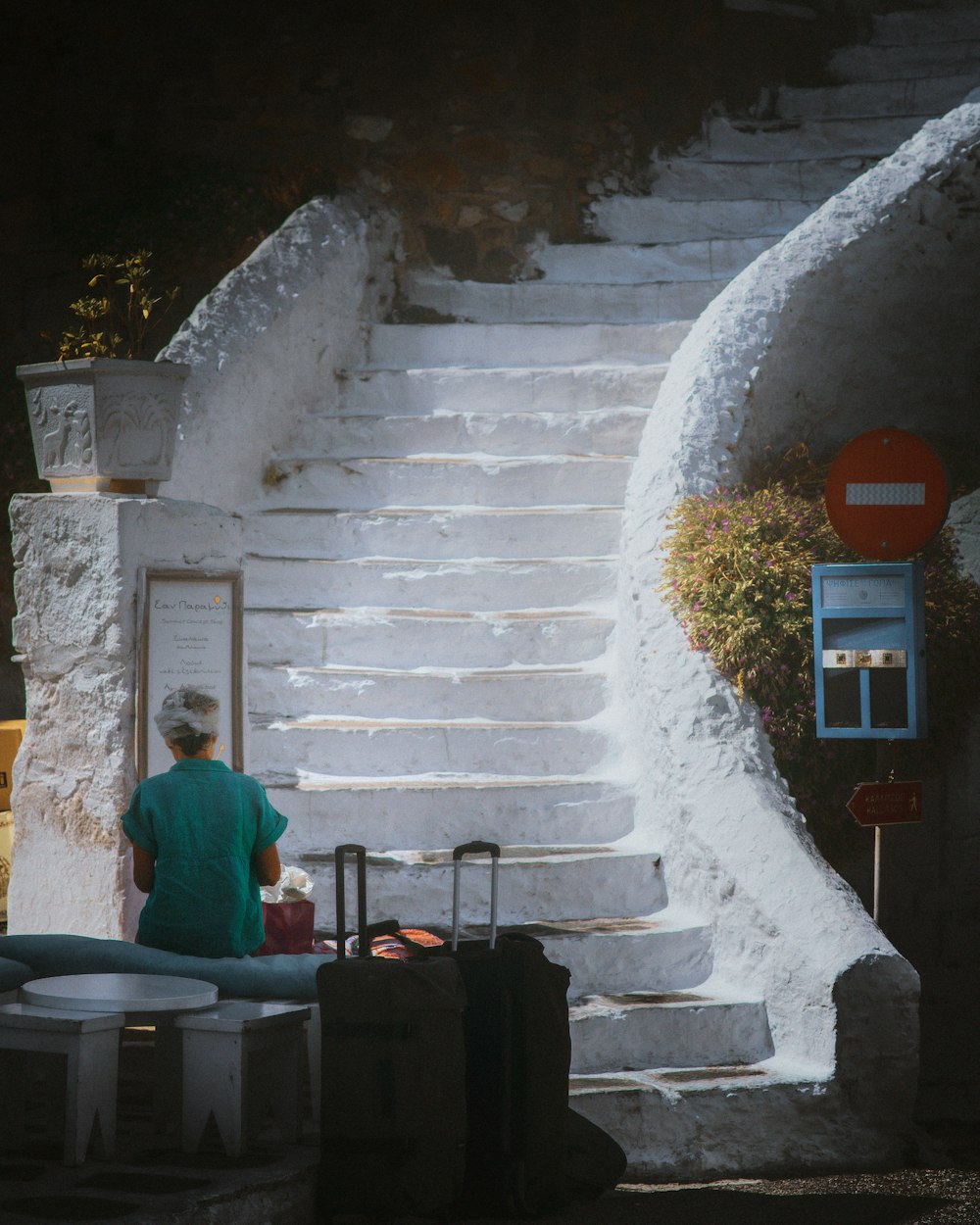 Un homme assis sur un escalier à côté des bagages