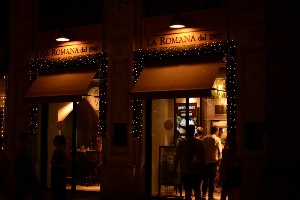 a group of people standing outside of a building at night