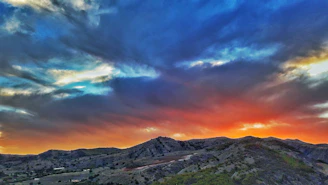 A breathtaking sunset over rolling hills with vibrant colors.