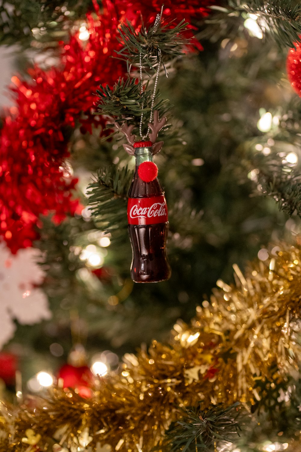 a coca cola ornament hanging from a christmas tree