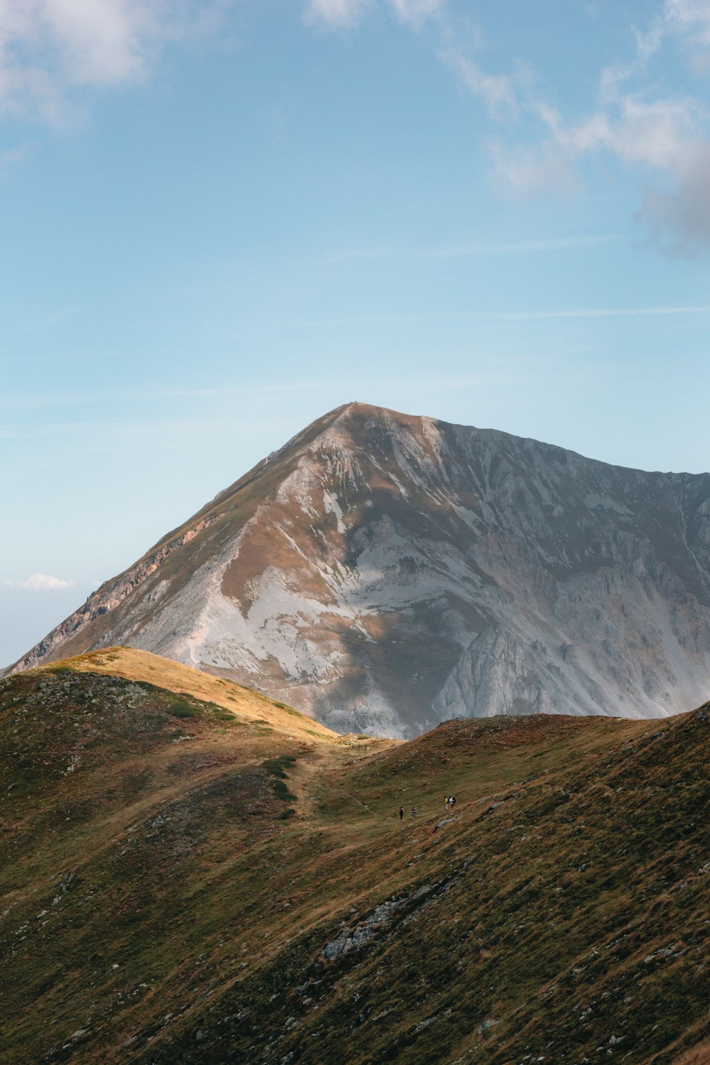 a large mountain with a few clouds in the sky