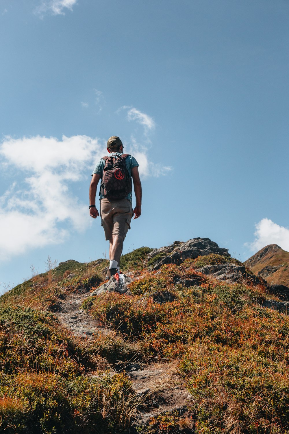 a man with a backpack walking up a hill