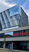 a building with a glass front and a red sign on it