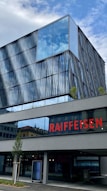 a building with a glass front and a red sign on it