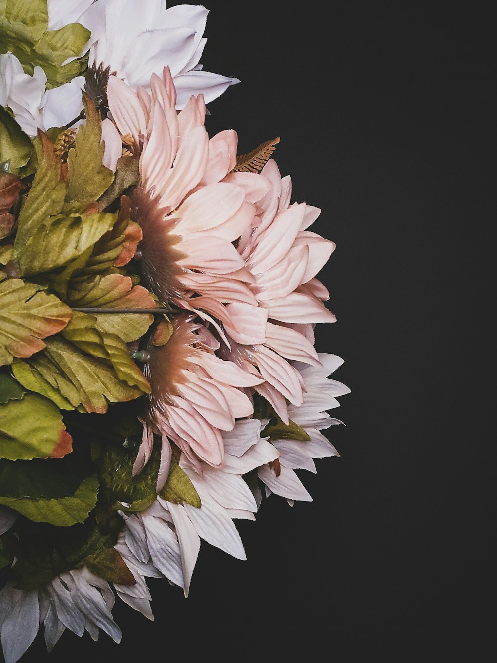 a bouquet of pink and white flowers on a black background