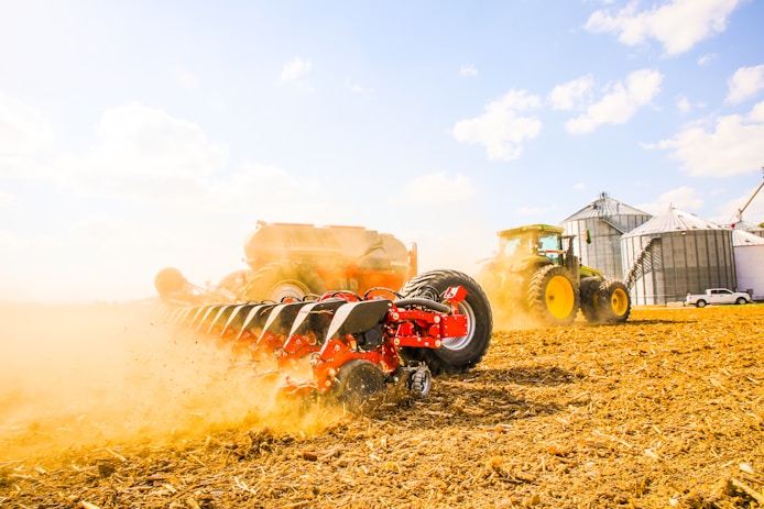 a tractor is driving through a field of hay