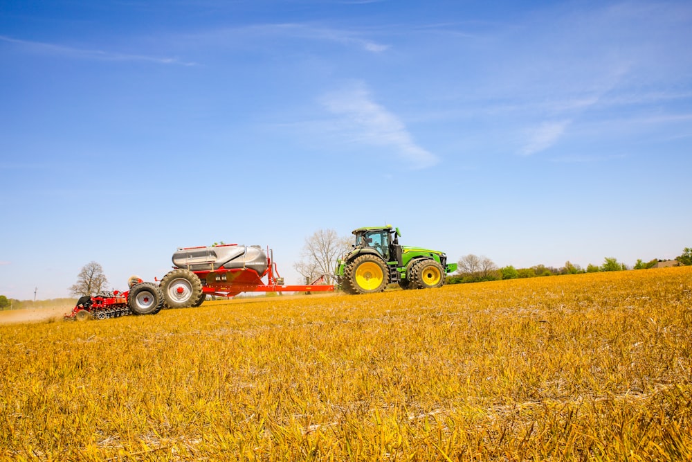 a tractor pulling a trailer behind it across a field