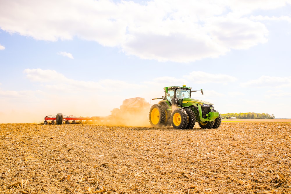 a tractor is plowing a field with a trailer