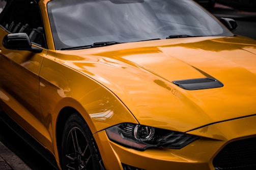 A bright yellow vinyl wrap on a compact car, highlighting the vehicle’s curves.