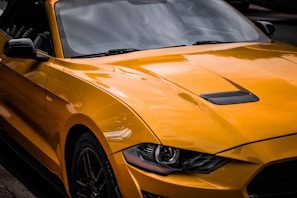 A vibrant yellow hatchback gleaming in natural light, highlighting its curves.