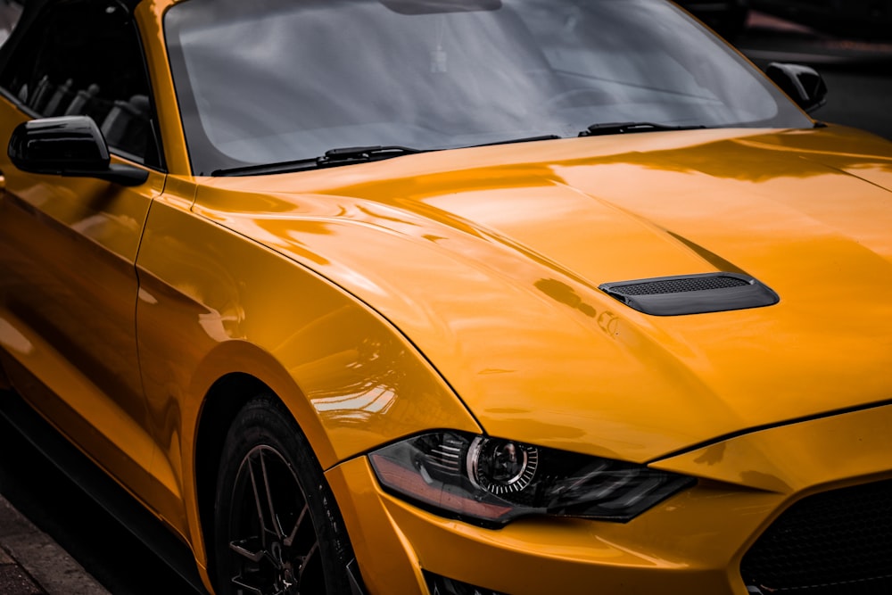 a yellow sports car parked on the side of the road