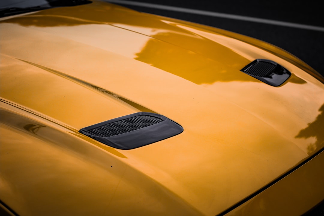 a close up of the hood of a yellow sports car,