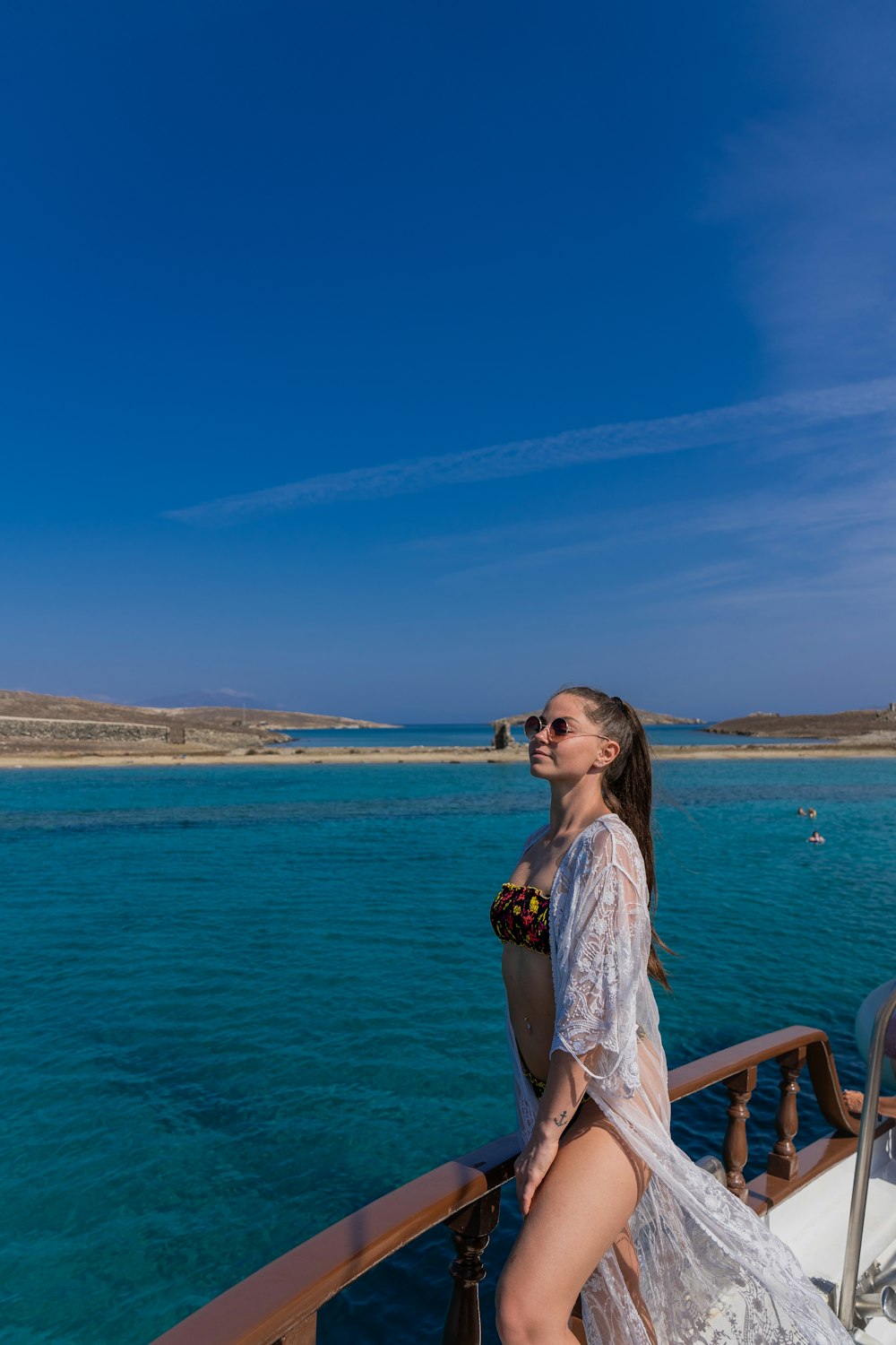 a woman in a white dress standing on a boat