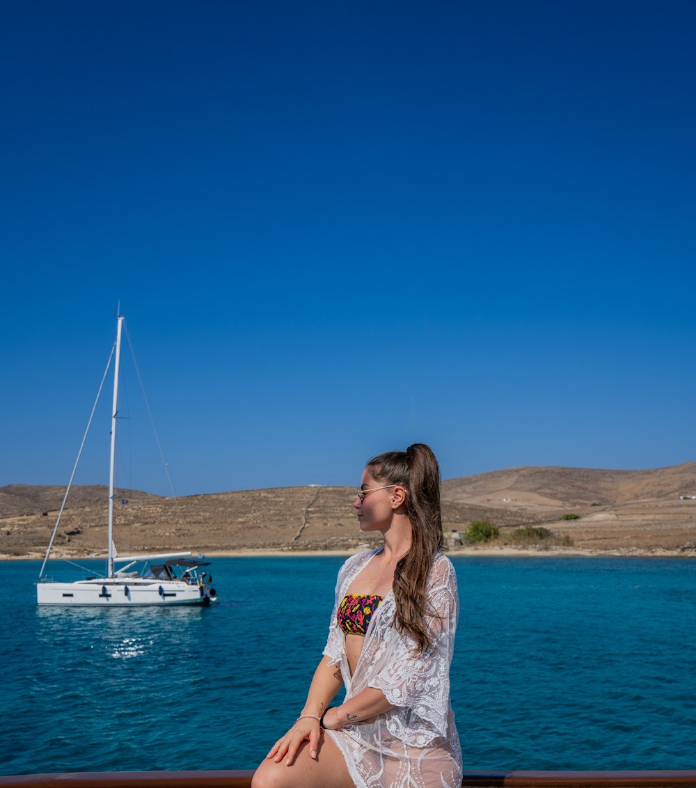a woman sitting on a boat looking out at the water