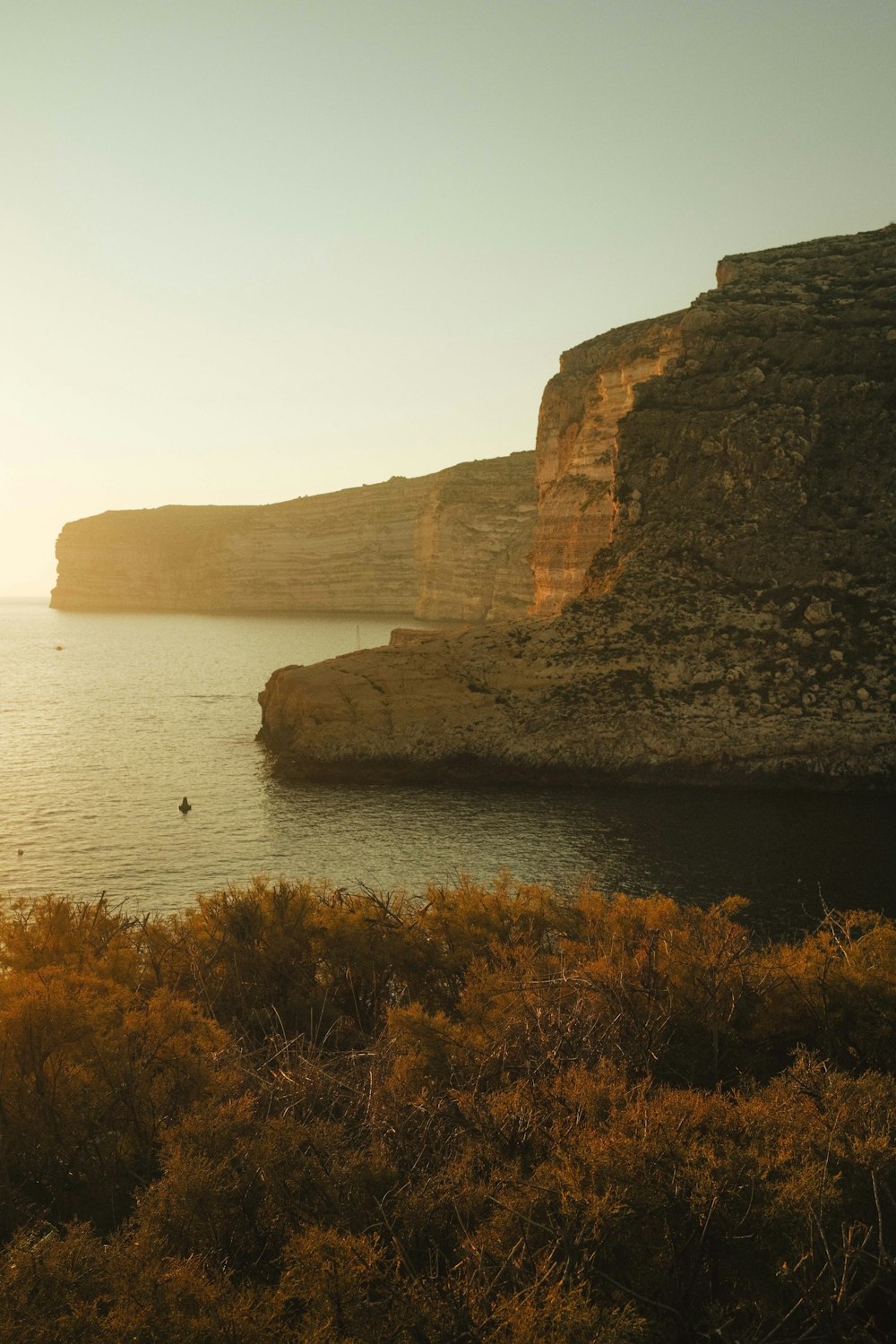 a body of water surrounded by a rocky cliff