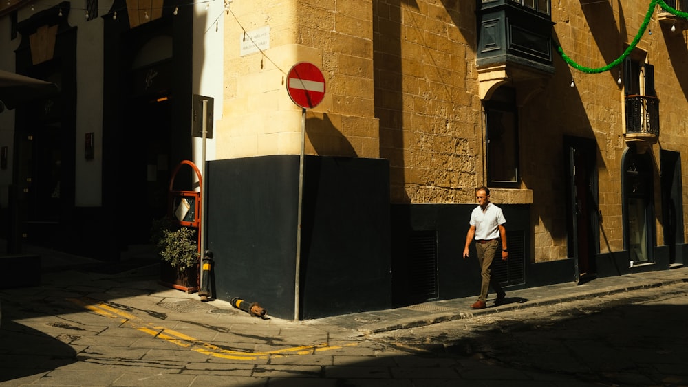 a man walking down a street next to a tall building