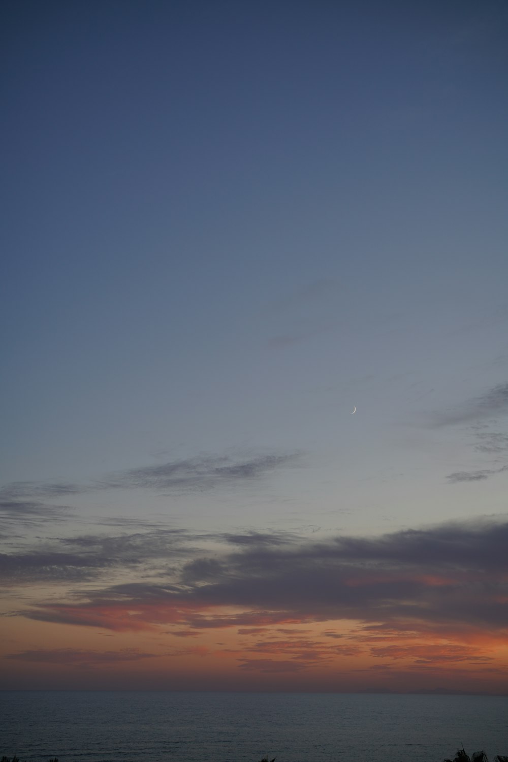 a plane flying in the sky over the ocean