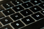 A close-up of a keyboard with the 'btl.co' domain typed on the screen.