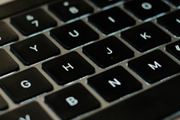 A close-up of a keyboard with the 'btl.co' domain typed on the screen.