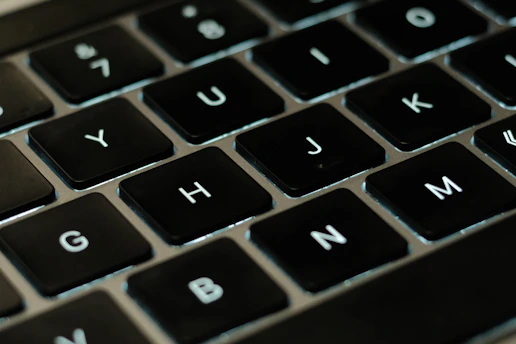 A close-up of a user typing letters into the scramblio word unscrambler on a sleek laptop.