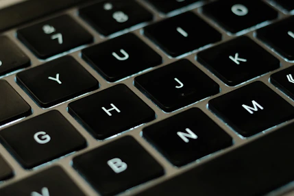 A close-up of hands typing on a laptop keyboard with EU flag icons floating above the screen.