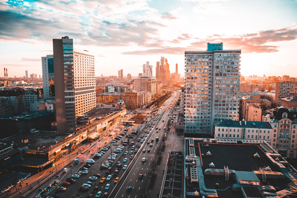 a city street filled with lots of traffic next to tall buildings