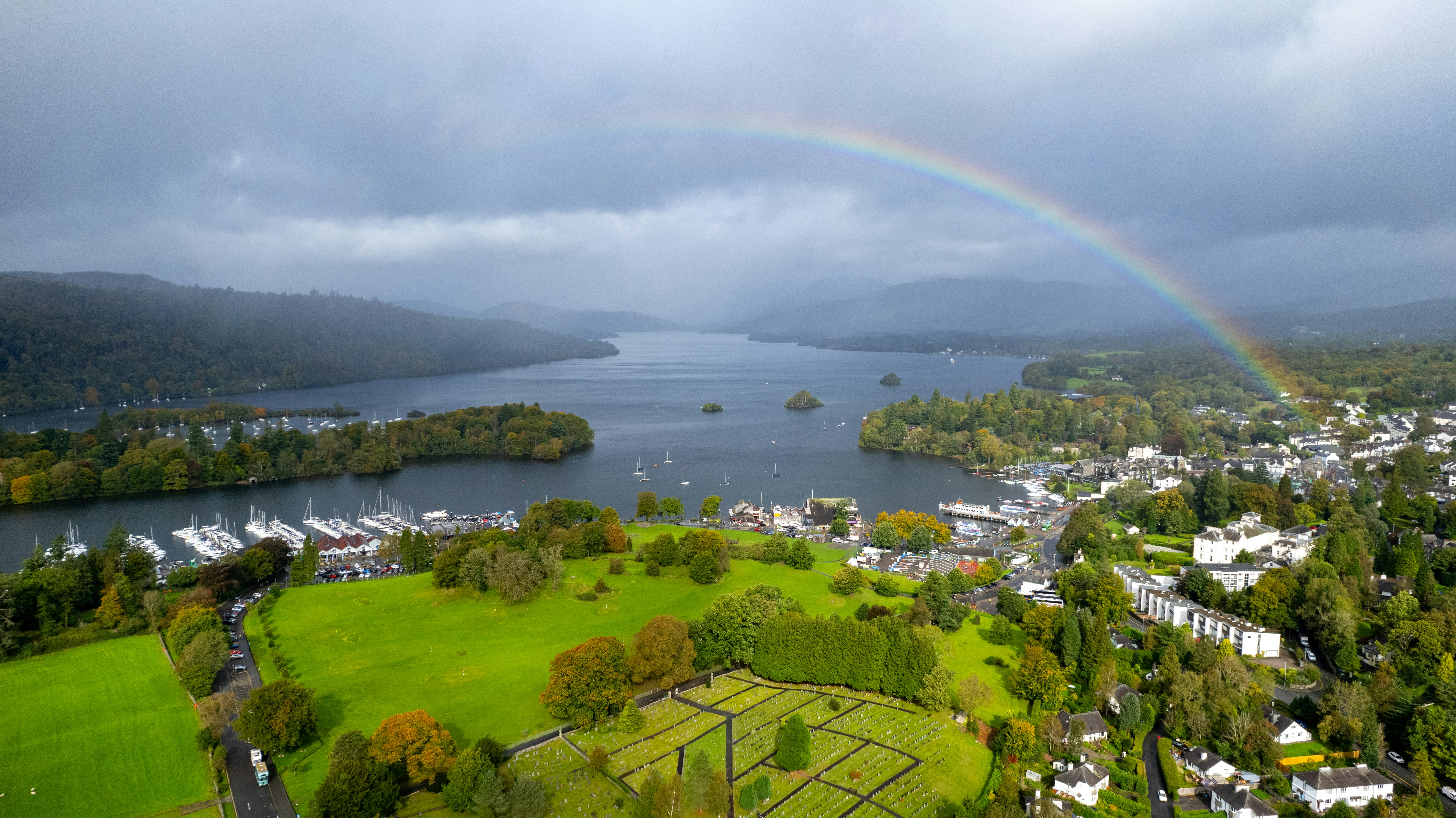 a rainbow in the sky over the small town of windermere