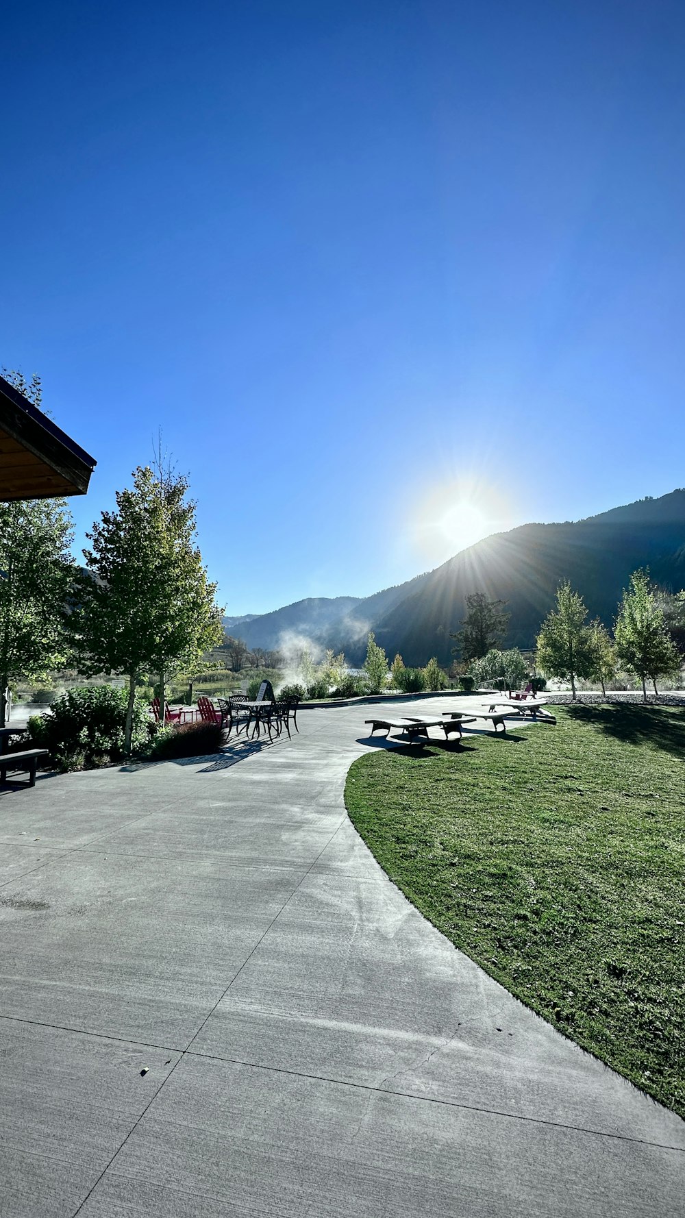 the sun is shining over a park with benches