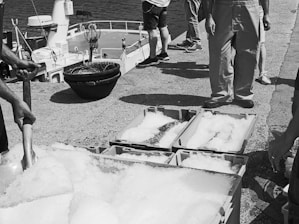 Refrigerated landing craft unloading fresh provisions at a coastal dock.