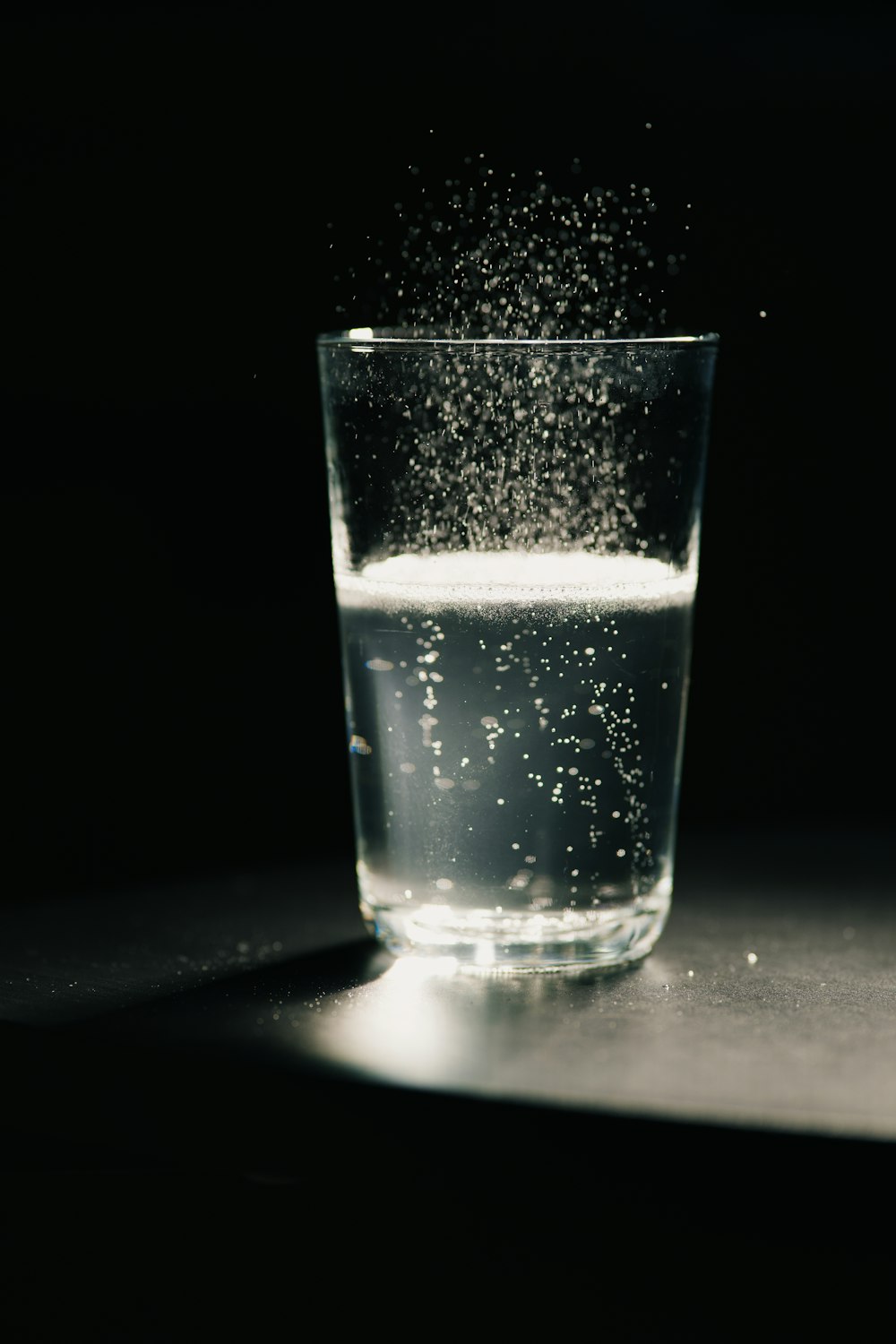 a glass filled with water sitting on top of a table
