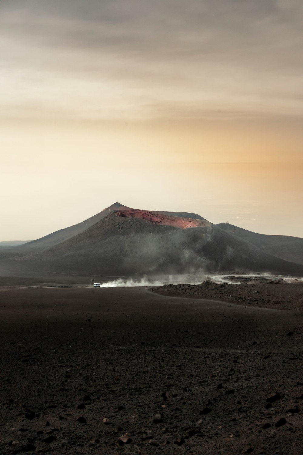 a mountain covered in smoke and dust on a cloudy day