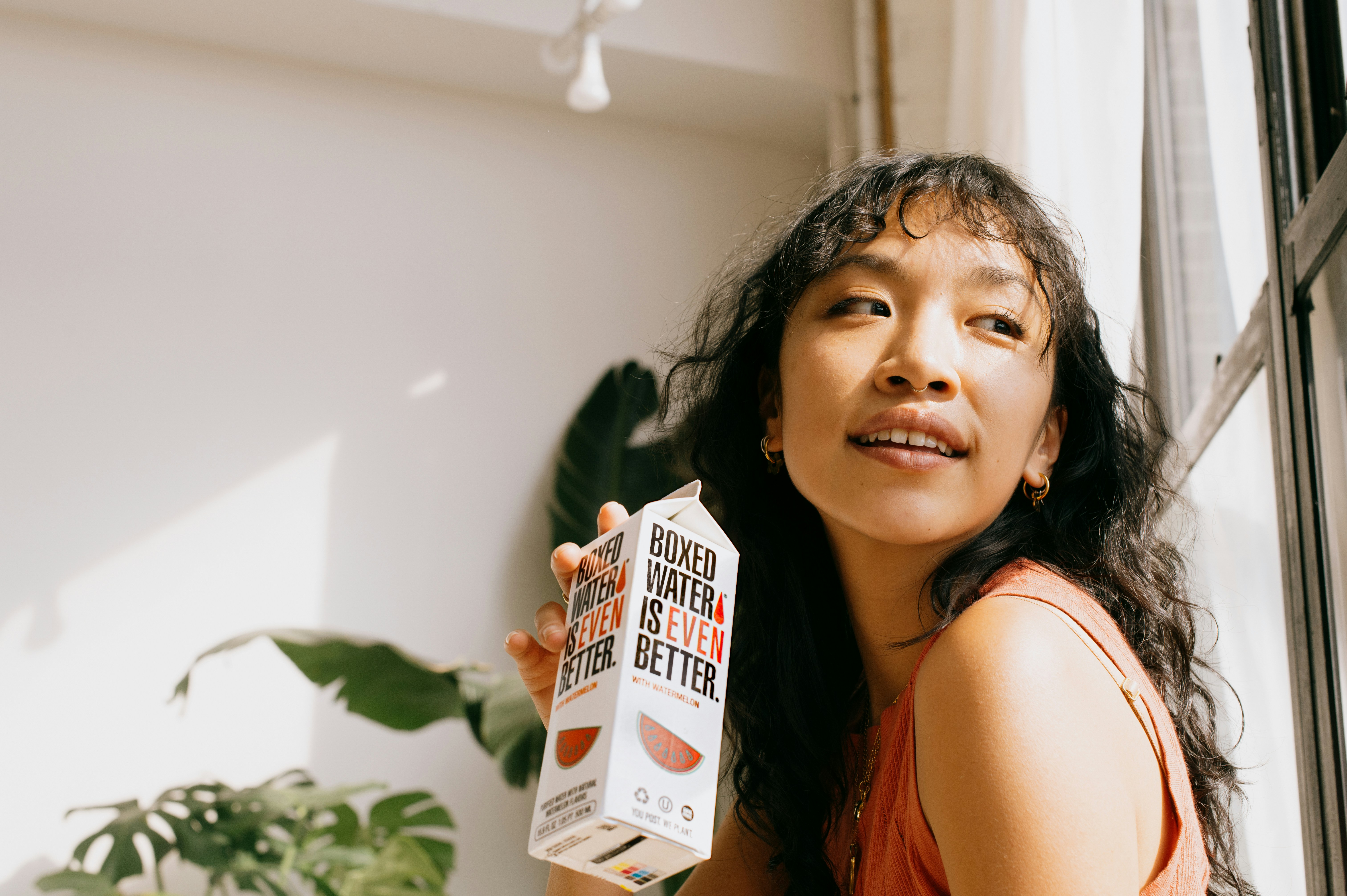 a woman holding up a carton of milk