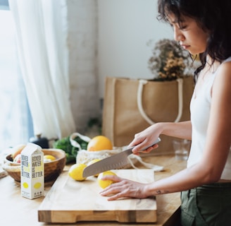 a woman cutting lemons on a cutting board