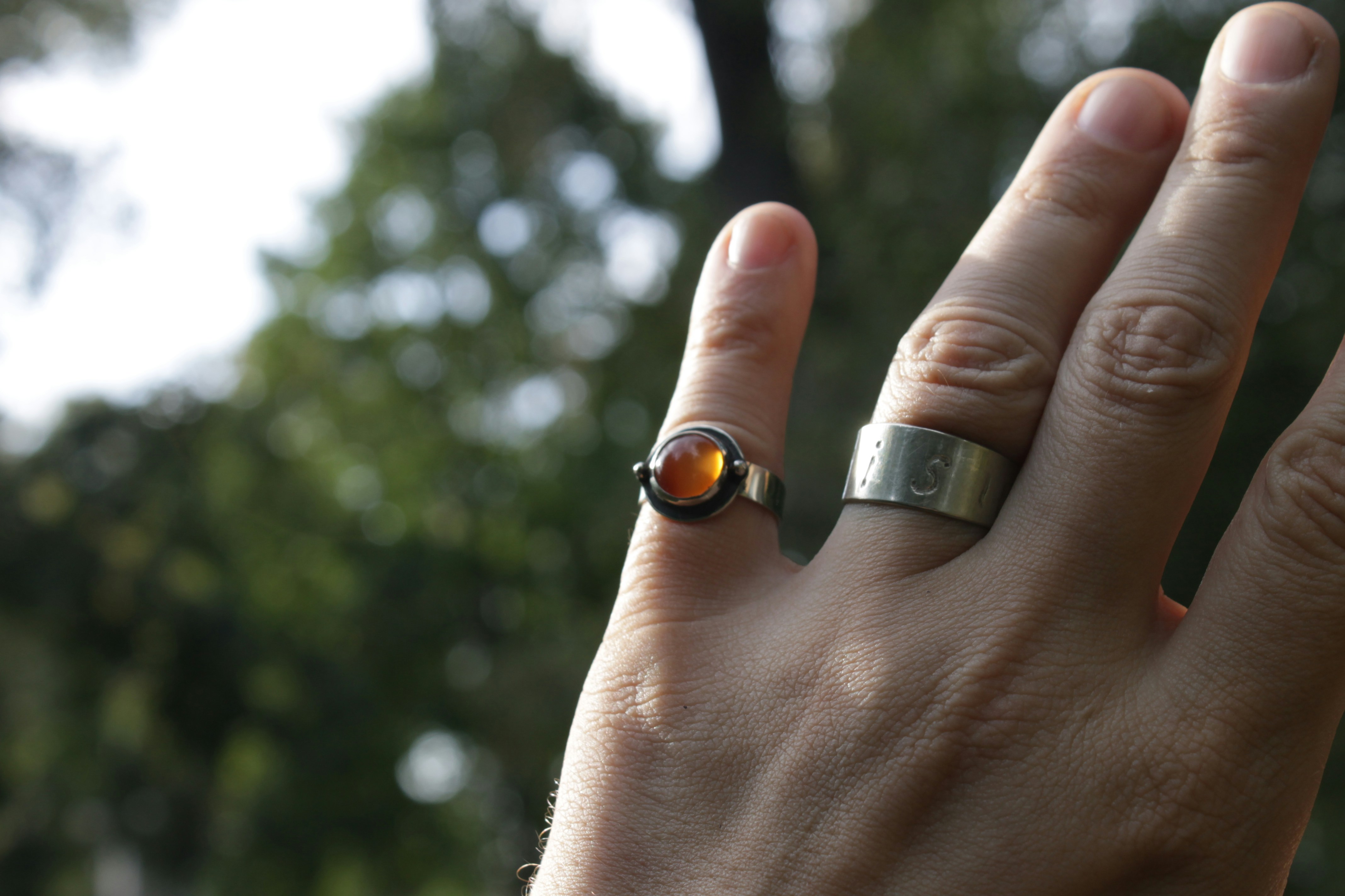 a person's hand with a ring on it
