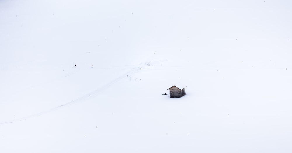 a small house in the middle of a snow covered hill