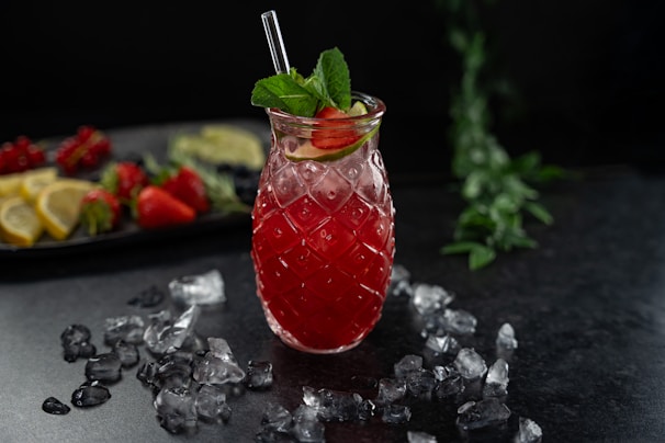 Brightly colored fresh fruit juices served in clear glasses with ice and mint leaves.
