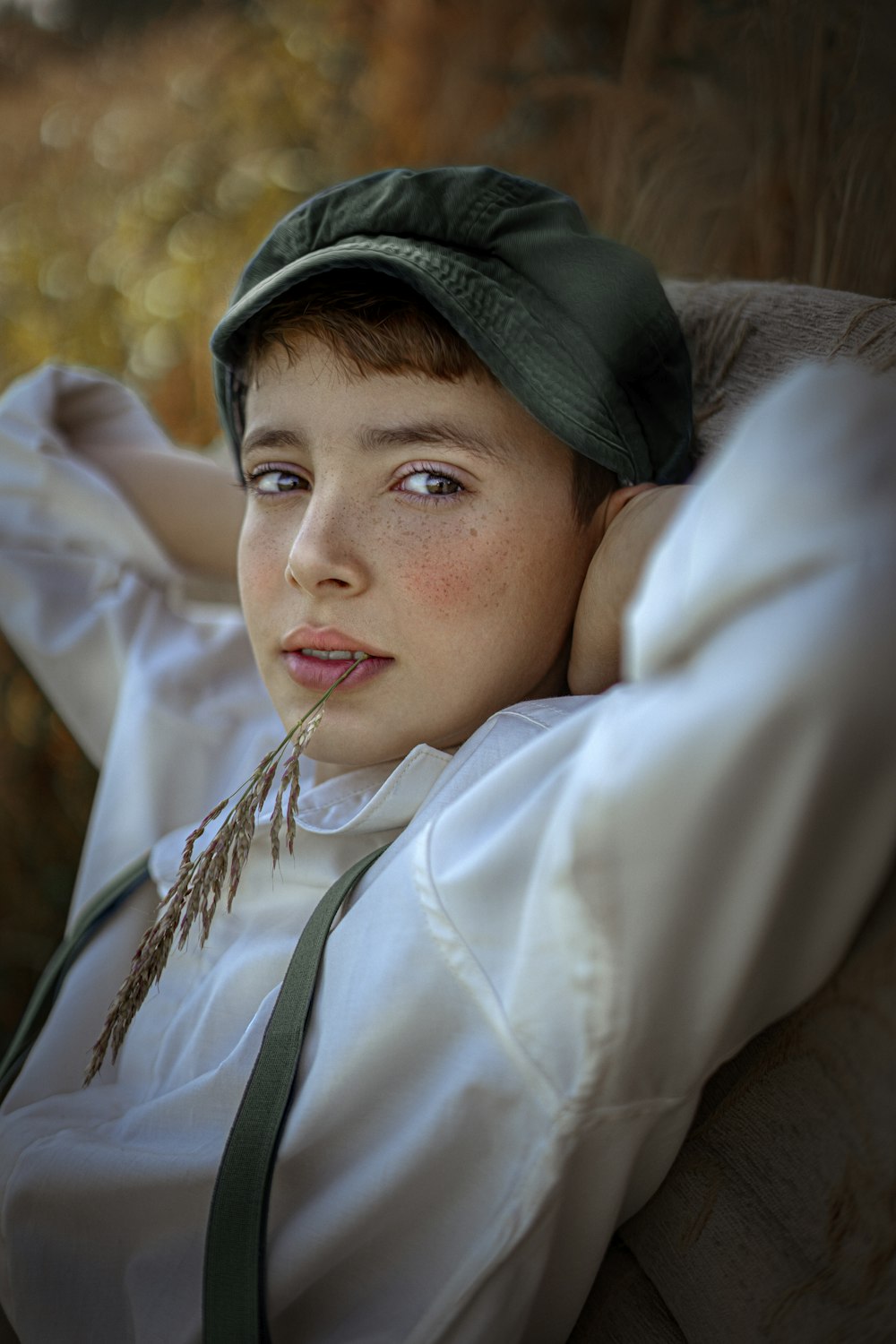 a young boy wearing a green hat sitting in a chair