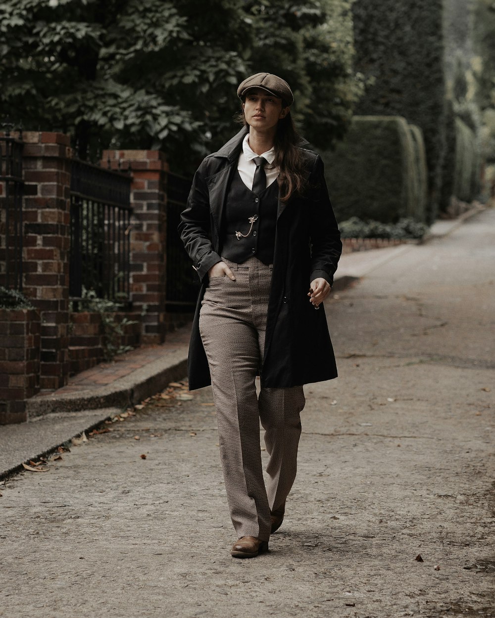 a woman in a suit and tie walking down a street