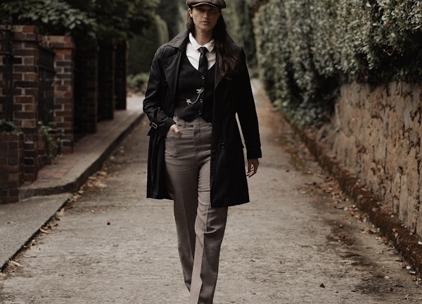 a woman walking down a street in a suit and tie