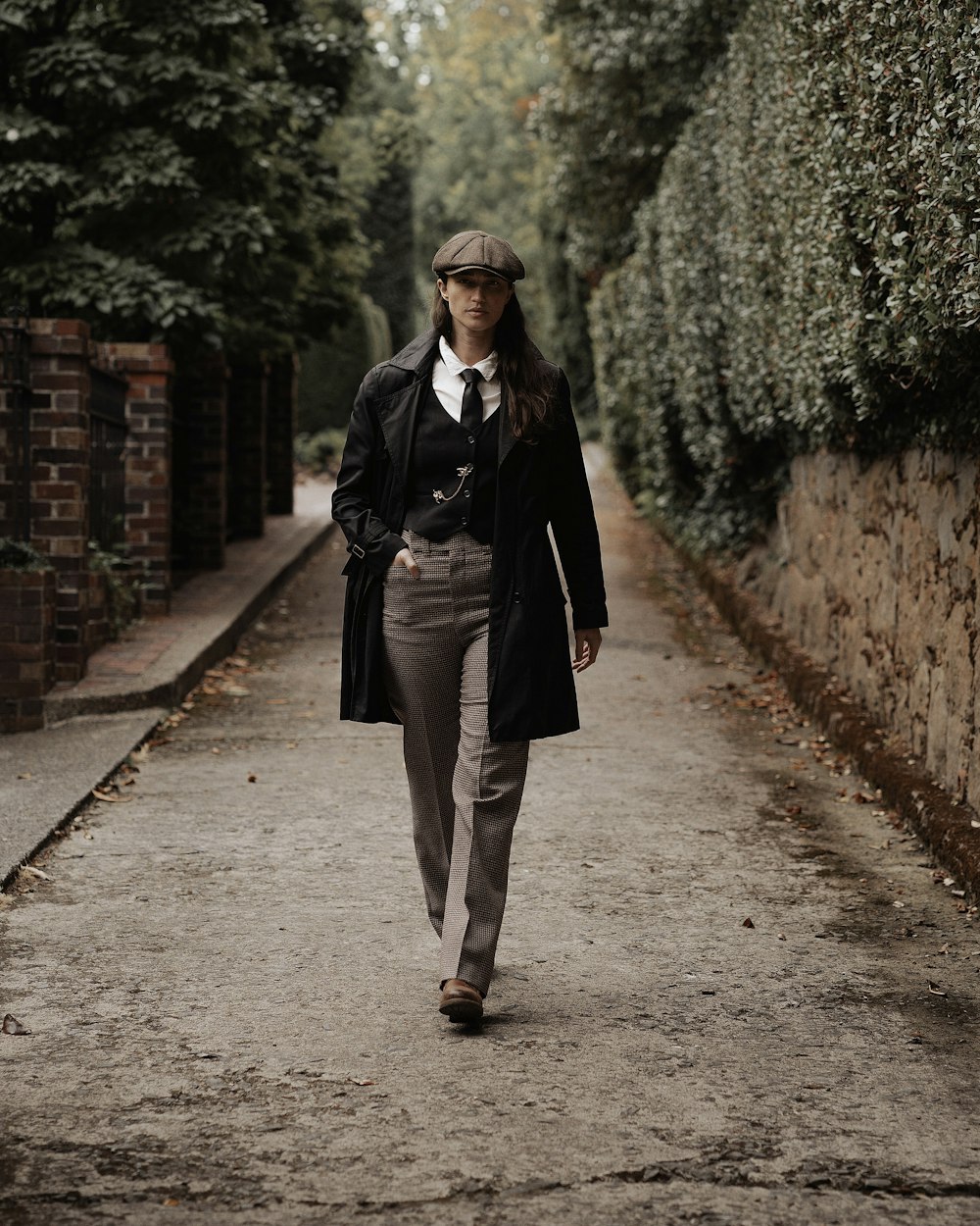 a woman walking down a street in a suit and tie