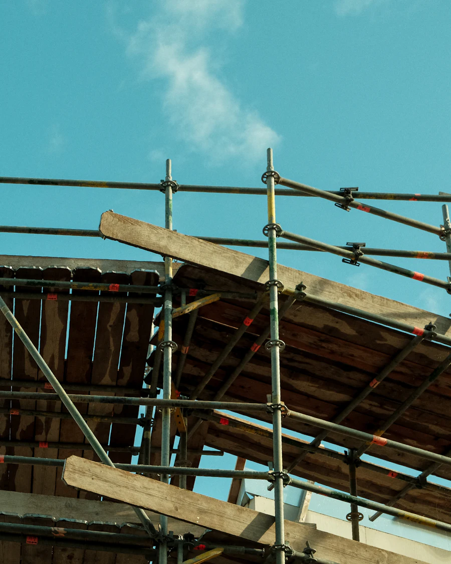 Scaffolding supporting a temporary roof structure under a blue sky