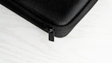 Close-up of a sleek black vxora iPhone case with soft velvet interior under soft lighting.