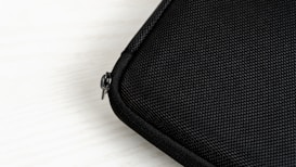 A close-up view of a textured black fabric case with a visible zipper.