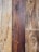 Natural wood planks with distinct grain patterns, showing variations in color from light tan to deep brown.